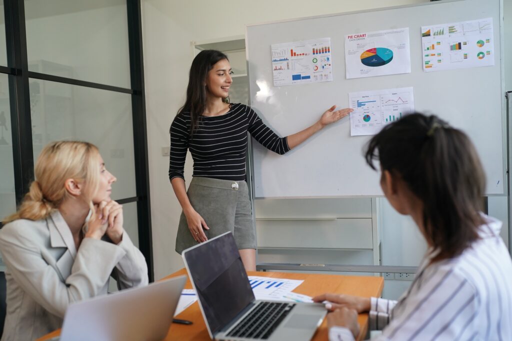 Businesswoman Pointing At Charts On whiteboard During Corporate Meeting Indoor